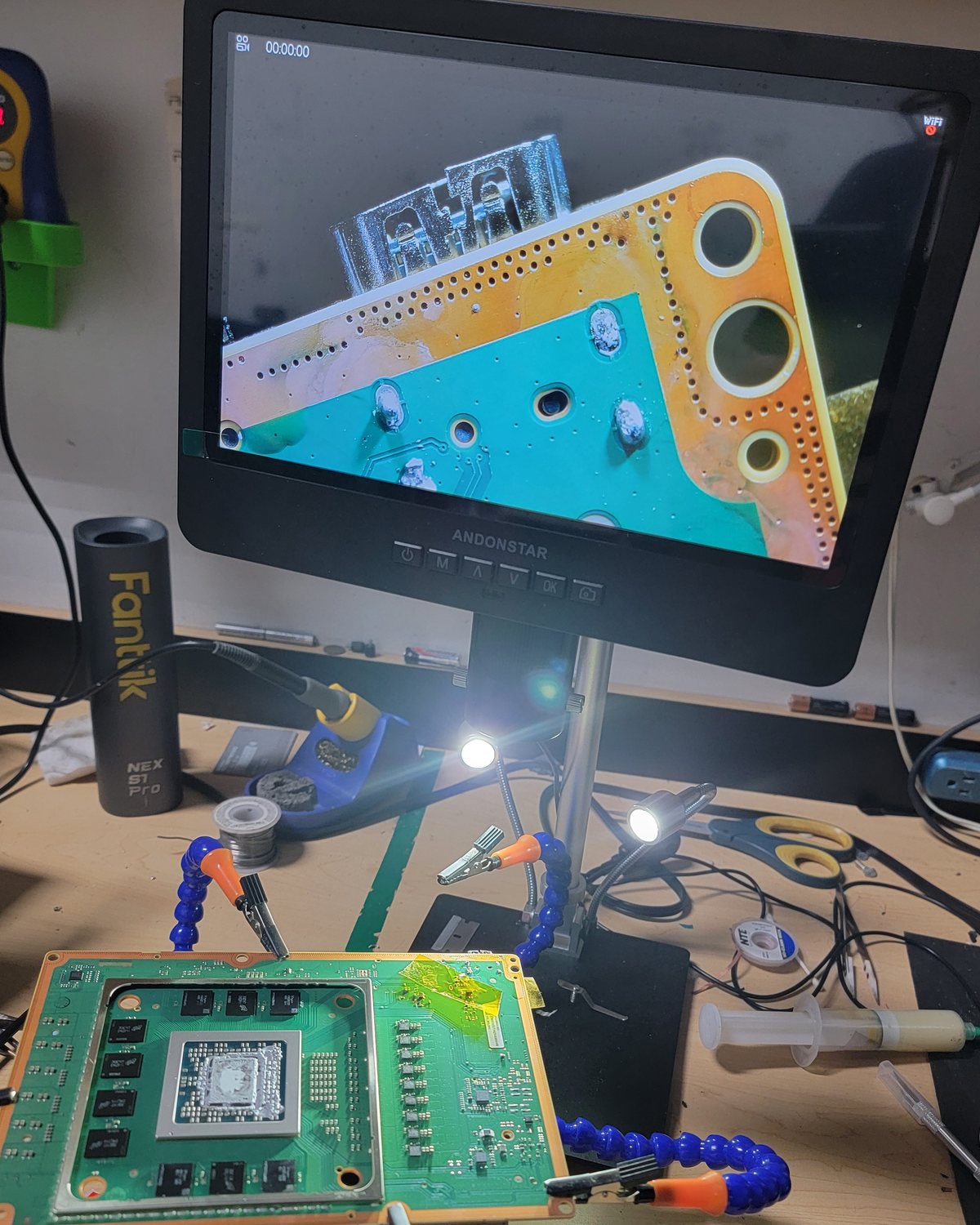 A console board under the digital microscope, showing the pads where a damaged HDMI port was removed